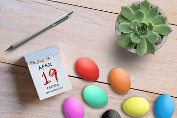 Abreißkalender mit Karfreitag 2019 und Ostereiern auf Holzuntergrund