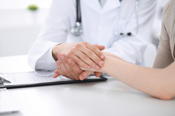 Obraz premium Hand of doctor reassuring her female patient. Medicine and health care concept