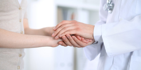 Hand of doctor reassuring her female patient. Medicine and health care concept
