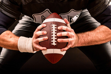 American football sportsman player on stadium with lights on black background.