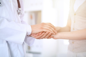 Hand of doctor reassuring her female patient. Medicine and health care concept