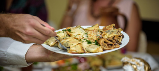 Waiter carrying plates with meat dish on some festive event, party or wedding reception