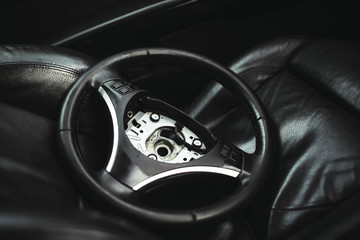 Fototapeta na wymiar repair of the steering mechanism of the car. Replacing the steering wheel in a sports car. safety bag.