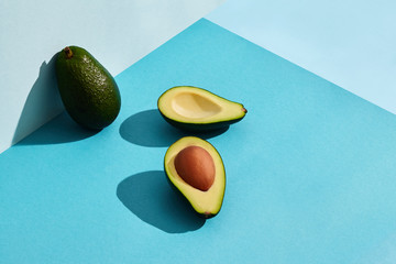 Composition of fresh fruits, whole avocado and two halfs of cutted avocado