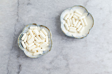 Piperine (black pepper extract). Immune System Support. Concept for a healthy dietary supplementation. Bright stone background. Top view. Copy space. 