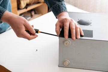 Technician disassemble computer with a screwdriver for problems diagnostic and repair