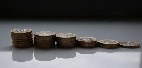 Euros stacked in piles with a white background and shadows visible