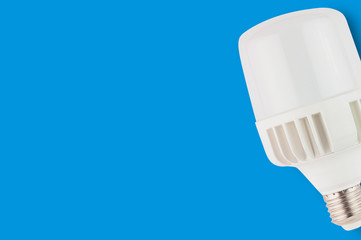 One new plastic led bulb on blue background with copy space. Saving and economy or green energy...