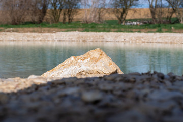 Fels am Sonnenlicht mit Wasser -See im Hintergrund