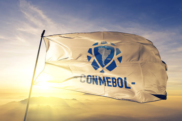 South American Football Confederation CONMEBOL flag waving sunrise mist fog