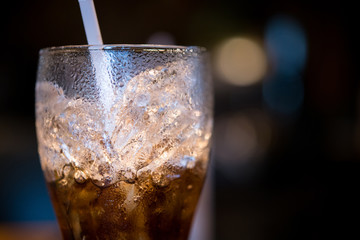 glass of cola with ice and straw