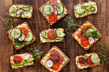Sandwiches with cream cheese, vegetables and salami.