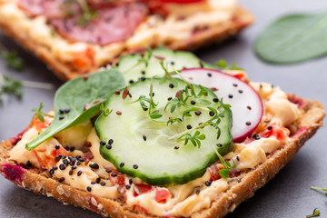 Sandwiches with cream cheese, vegetables and salami.
