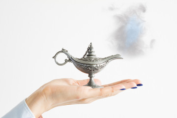 Woman holding genie lamp, hoping for a miracle from the magic spirit