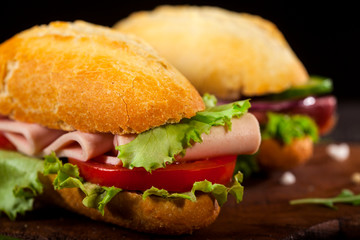Fresh burgers on wooden table and dark background