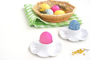 Multi-colored Easter eggs in stands on a white background. Easter concept.