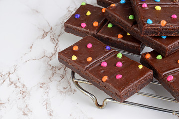 chocolate fudge brownies with candy pieces on cooling rack
