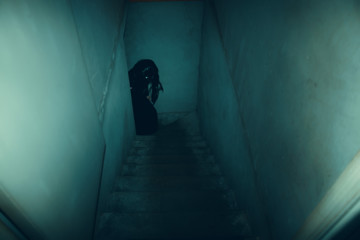 Dark figure on the old concrete stairs in the descent to the basement. - 255761087