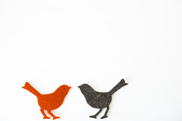 Two amorous little orange and black birds in front of white background