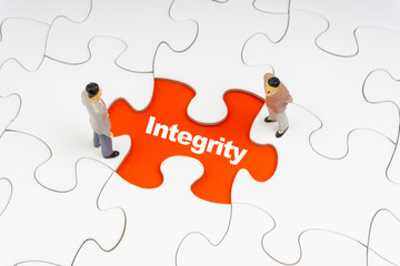 INTEGRITY inscription written on jigsaw puzzle and businessman miniature. Business and motivation...