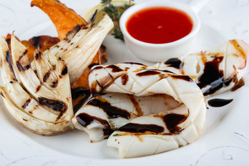 Kalmar fried on a grill in soy sauce moves with leek on a grill © maleficenta