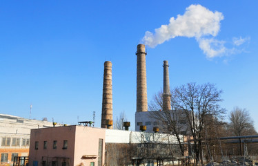 Factory pipes with thick white smoke polluting environment in blue sky background, environmental...