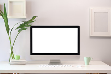 Mock up loft creative workspace with blank white screen computer