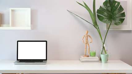 Stylish minimalistic workplace with blank screen laptop