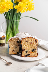 Easter cake and yellow flowers, grey background, on a white plate