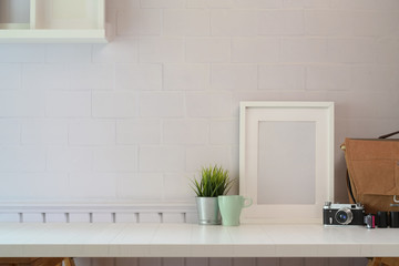 Mockup poster with vantage camera on white wooden desk space and copy space.