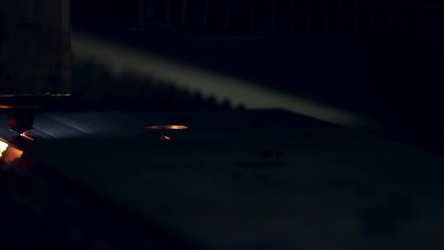 Industrial robotic laser cutter cuts metal parts with great precision. Industrial cnc plasma cutting of metal plate. Modern industrial technology. Lot of bright sparks light. Slow motion video.