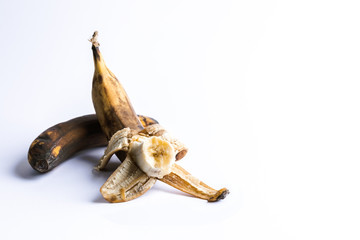 Two overripe blackened ugly bananas on white background.