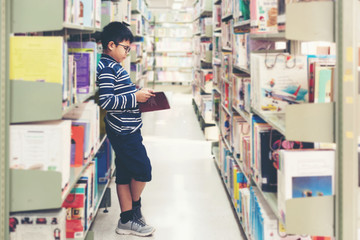 Kids asia boy reading books for education and go to school in library . Education and Lifestyle Concept
