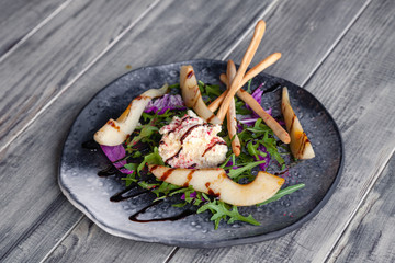 Closeup fresh summer diet salad with goat cheese, pear, Chinese cabbage, arugula, bread sticks with balsamic dressing. Concept professional food shooting, photo session new menu