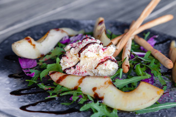 Closeup fresh summer diet salad with goat cheese, pear, Chinese cabbage, arugula, bread sticks with balsamic dressing. Concept professional food shooting, photo session new menu