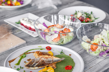 Many different dishes, fish, salads served on restaurant table. Concept banquet, buffet, party, trying new menu