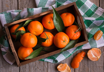 Ripe delicious mandarines with zest on dark wooden table
