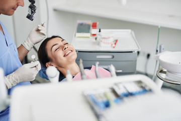 Beautiful young lady smiling during checkup at dental clinic