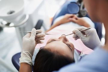 Young lady receiving teeth treatment in modern dental clinic