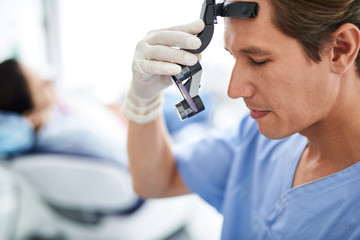 Focused dentist with closed eyes preparing for dental procedure