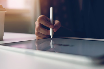 Women hand are using the tablet on the desk. Take your screen to put on advertising.