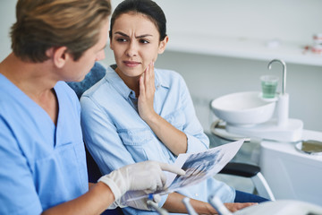 Young lady discussing her dental problems with dentist
