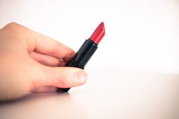 Taking a lipstick: Female hand is taking an elegant, red lipstick