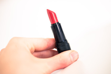 Taking a lipstick: Female hand is taking an elegant, red lipstick