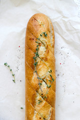 French baguettes with thyme on kraft paper. Mini baguette bread. Top view food, close up