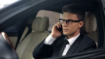 Upset politician talking on phone, sitting in car, business trip, travelling