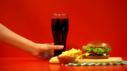 Obraz na płótnie Canvas Woman hand taking glass of refreshing beverage, fast food order in restaurant