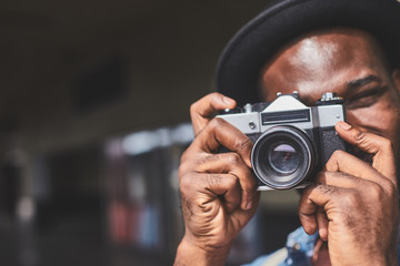 Portrait of young man with film camera outdoors