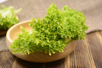 Fresh organic green lettuce salad leaves in wooden bowl Healthy food concept