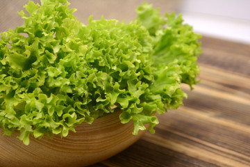 Fresh organic green lettuce salad leaves in wooden bowl Healthy food concept